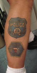 Police tatoos adorn Sgt. Spriggs' body.