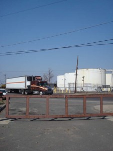 Tractor trailers pass Pulaski Park en route to I-95.